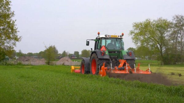 Traktor rijdt over grasland