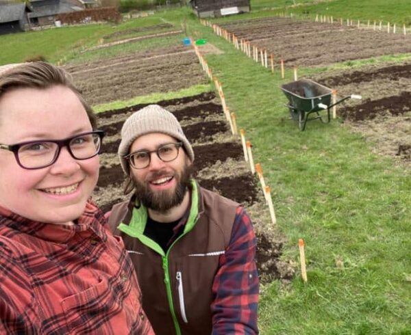 Man en vrouw in een moestuin met kruiwagen