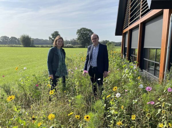 Man en vrouw staan in weiland met gekleurde bloemen