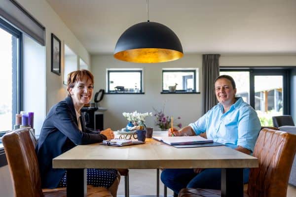 Twee vrouwen zitten aan een keukentafel