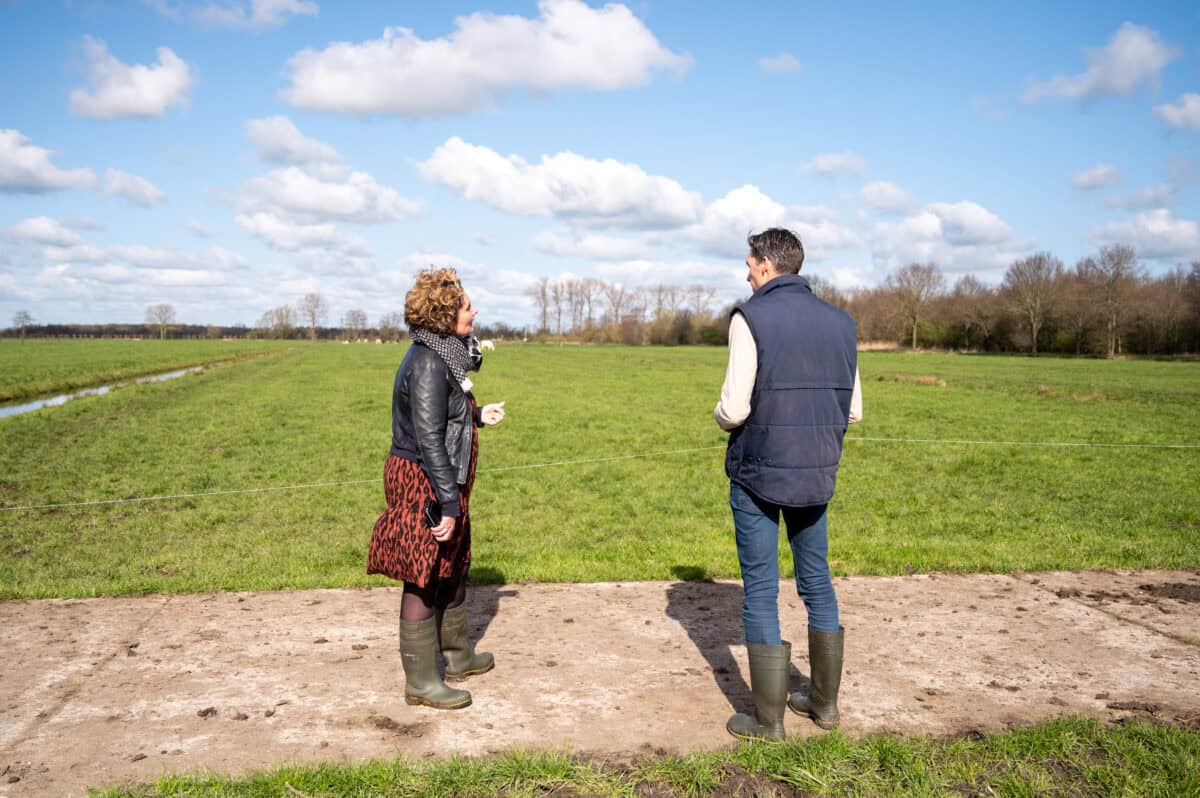 Man en vrouw staan in een weiland te praten