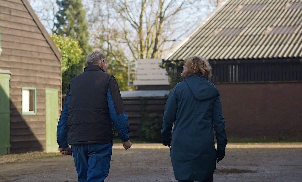 Man en vrouw lopen op een boerenerf