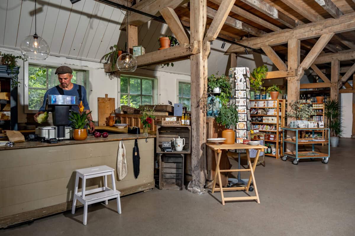 Man staat achter kassa in boerderijwinkel